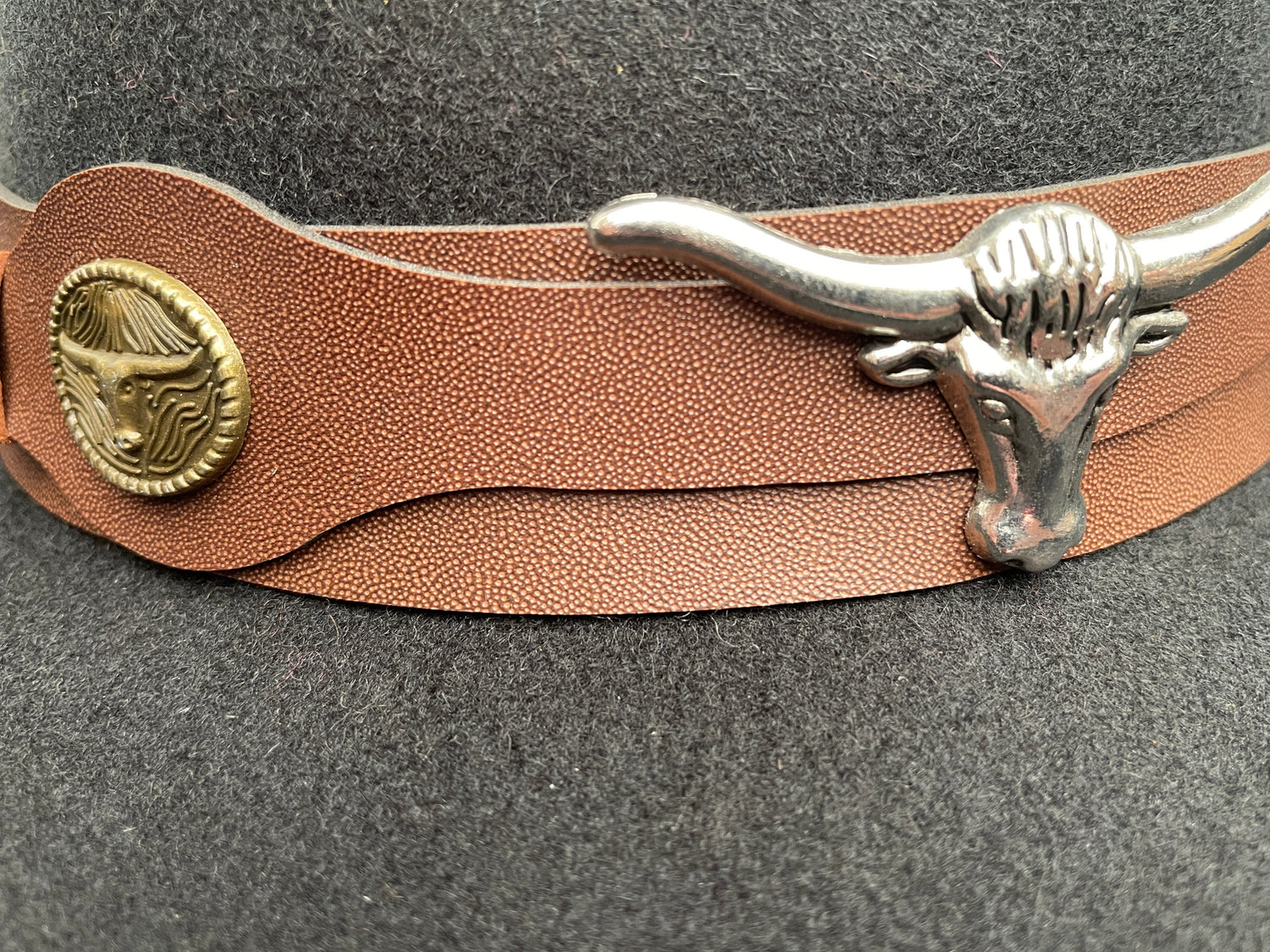Black cowboy hat made of high-quality felt with leather band and metal bull head