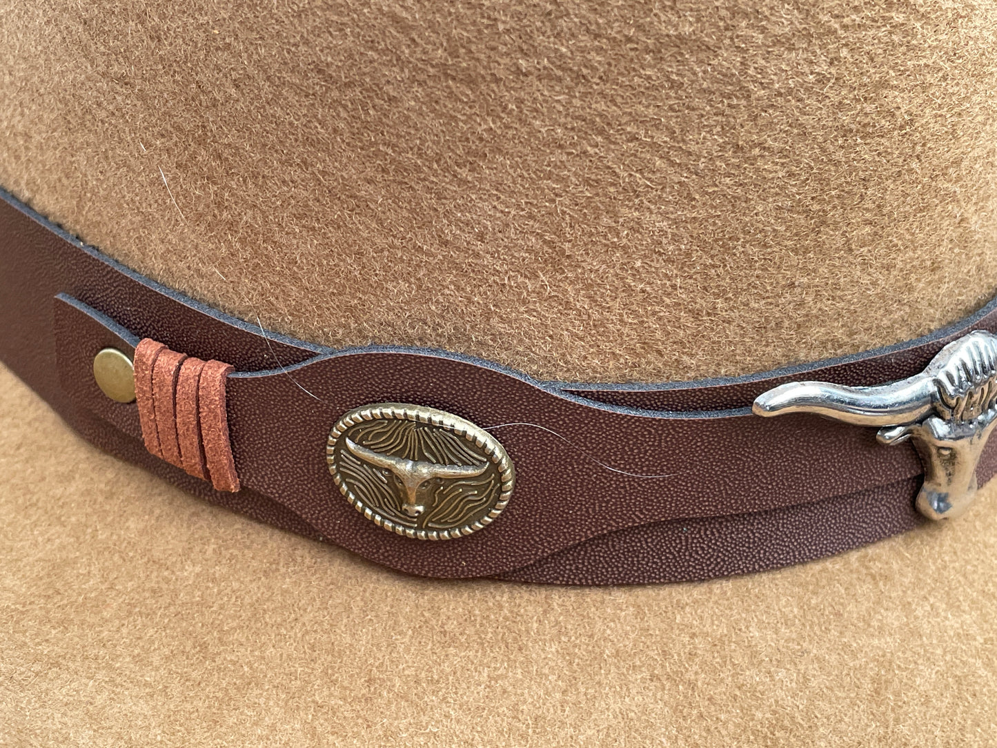 Brown cowboy hat made of high-quality felt with leather band and metal bull head