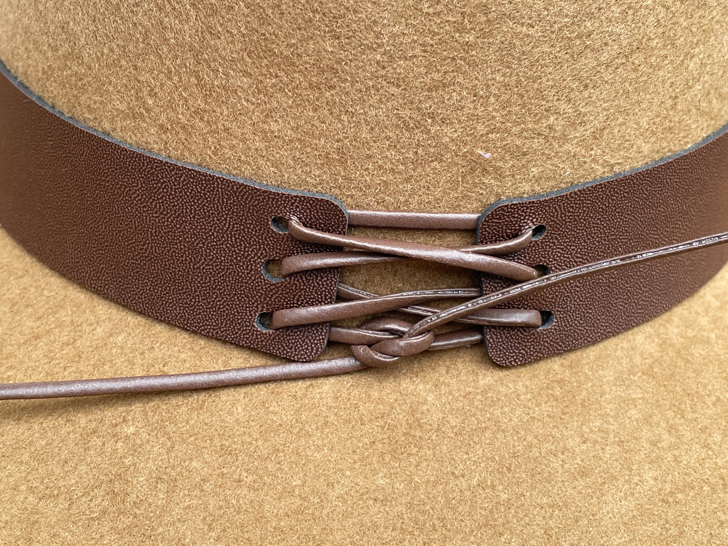 Brown cowboy hat made of high-quality felt with leather band and metal bull head