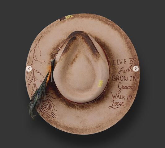 Light brown felt hat in the shape of a Fedora with various accessories