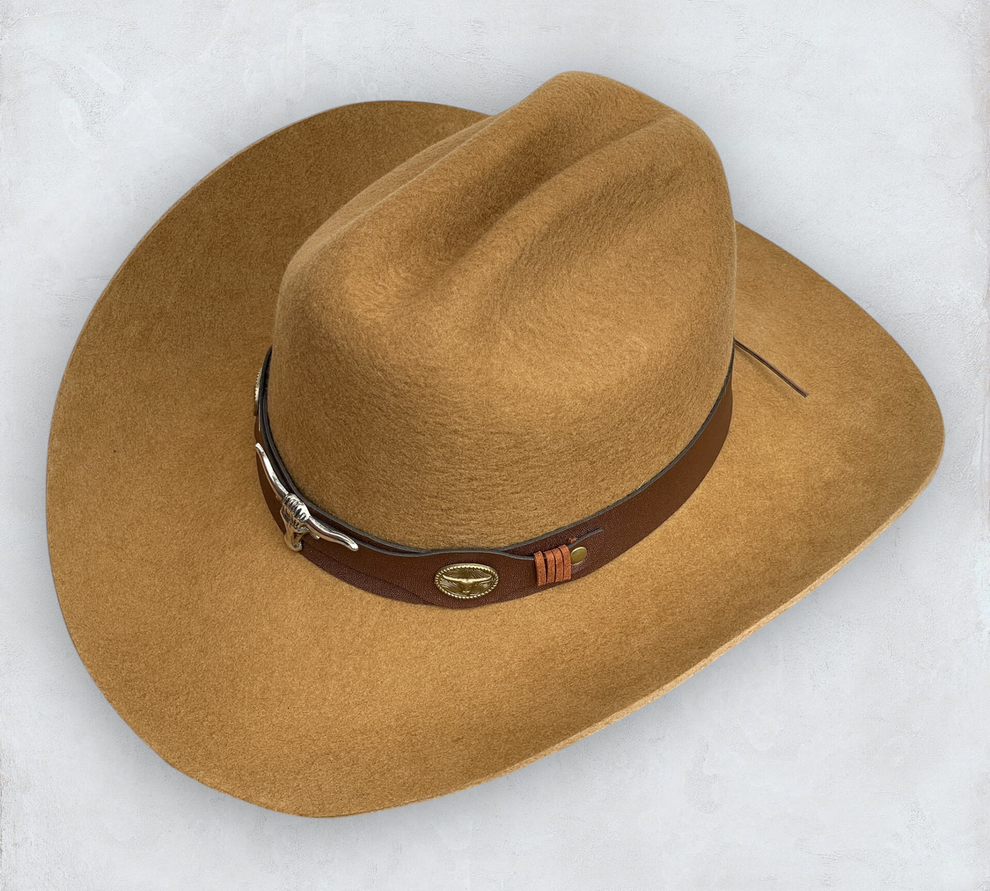 Brown cowboy hat made of high-quality felt with leather band and metal bull head