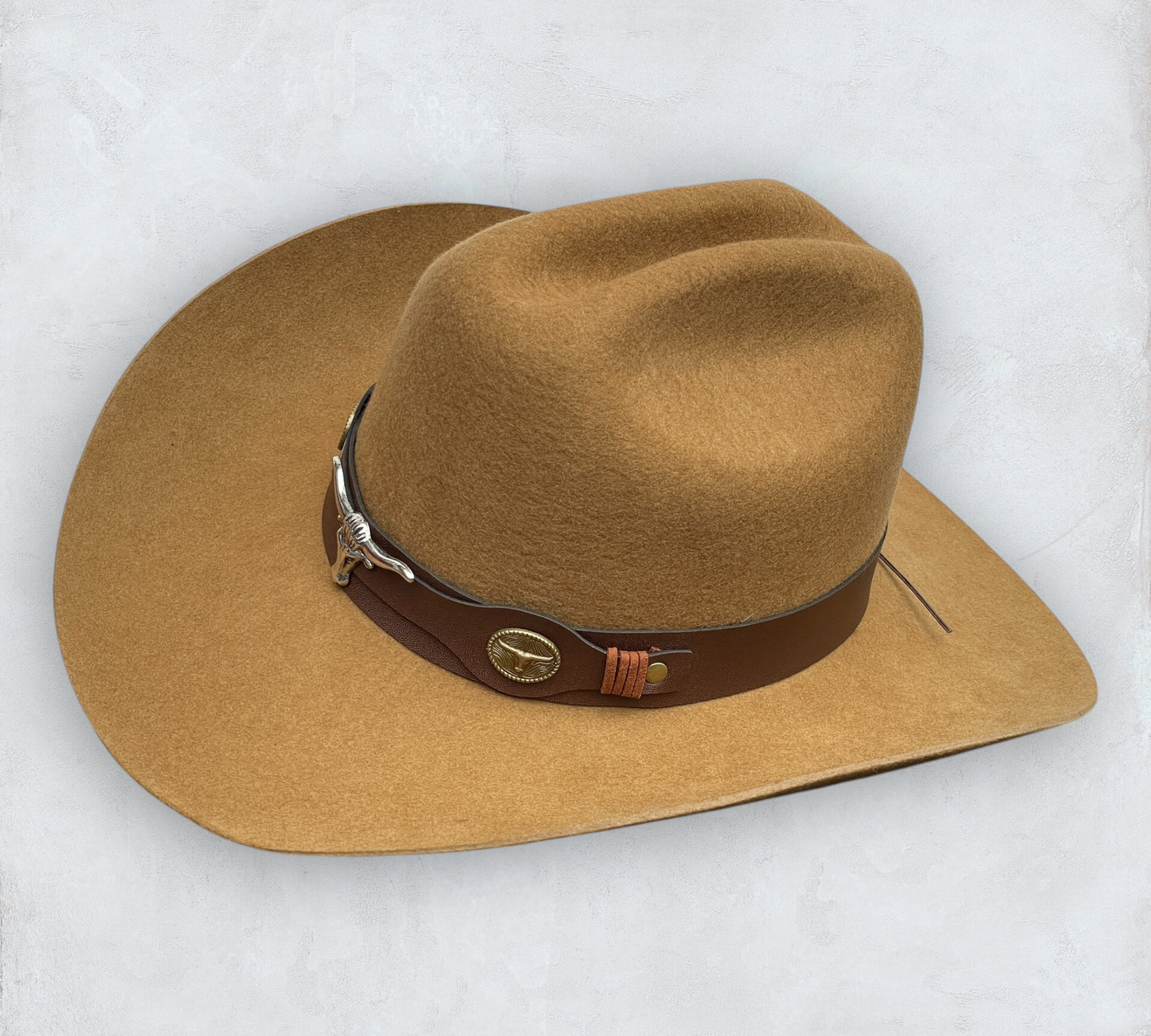 Brown cowboy hat made of high-quality felt with leather band and metal bull head