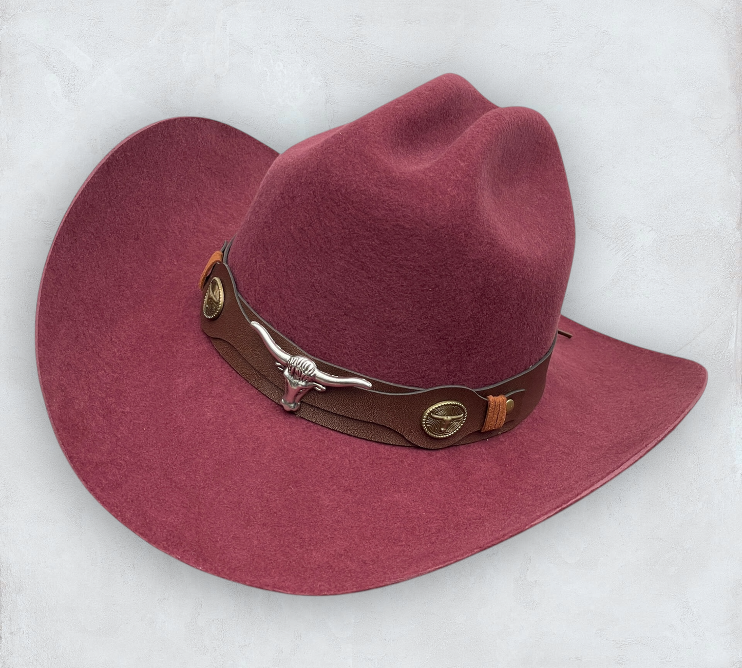 Red cowboy hat made of high-quality felt with leather band and metal bull head