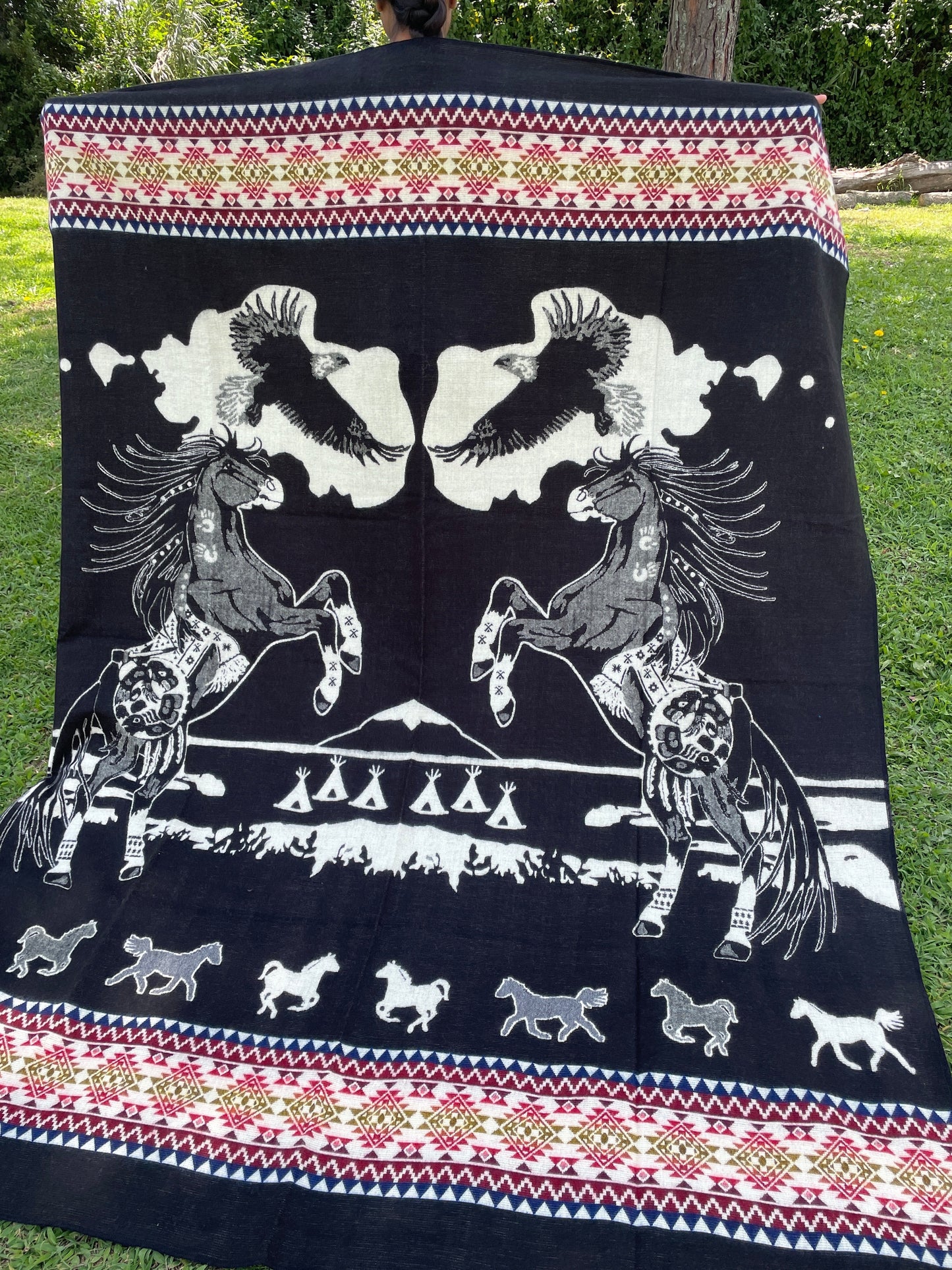 TomHats alpaca blanket in black, featuring eagle and horse motifs as well as traditional indigenous patterns, made of soft wool.