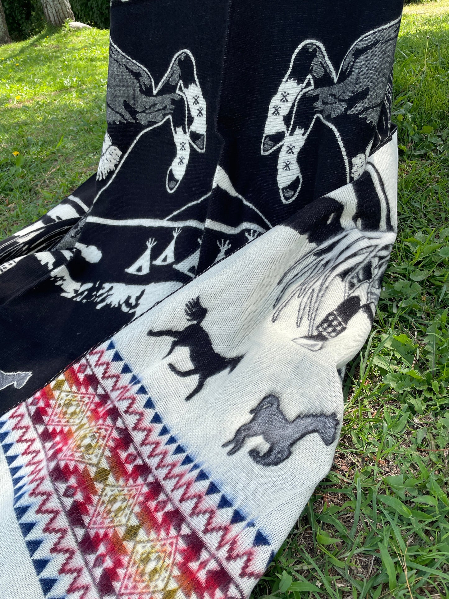 TomHats alpaca blanket in black, featuring eagle and horse motifs as well as traditional indigenous patterns, made of soft wool.