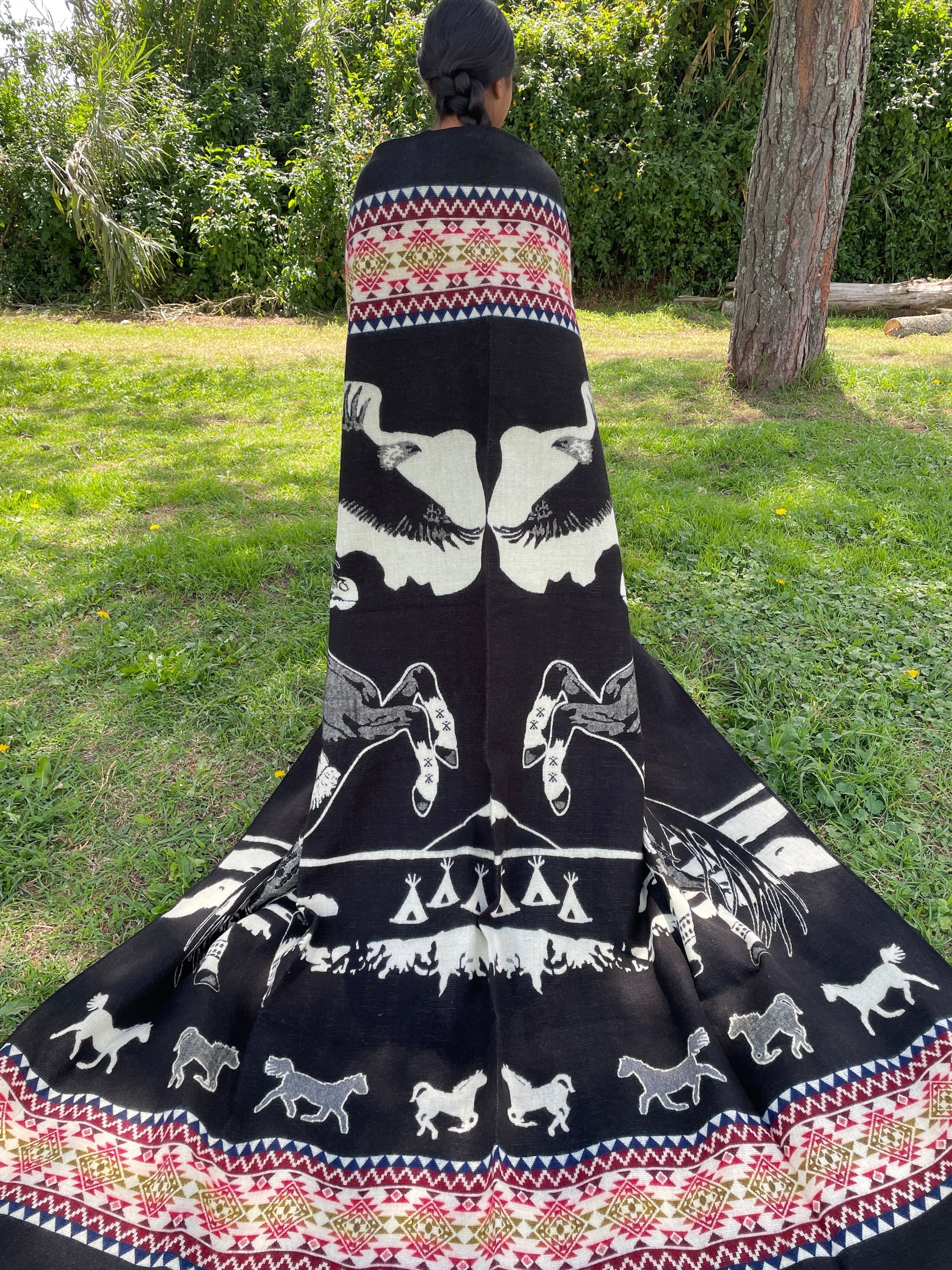 TomHats alpaca blanket in black, featuring eagle and horse motifs as well as traditional indigenous patterns, made of soft wool.