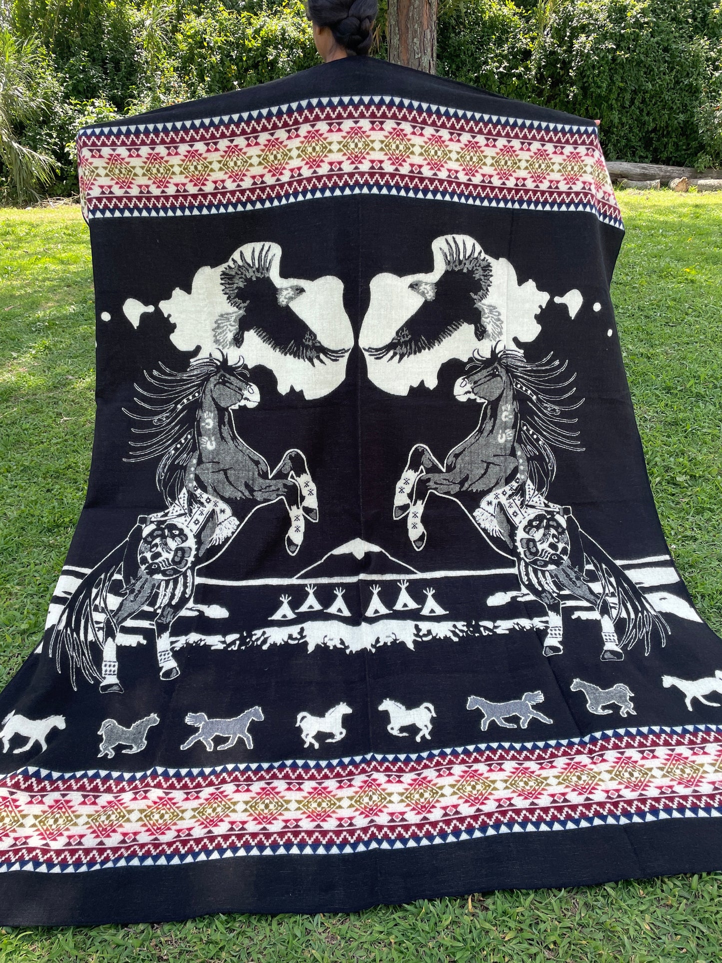 TomHats alpaca blanket in black, featuring eagle and horse motifs as well as traditional indigenous patterns, made of soft wool.