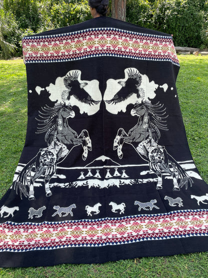 TomHats alpaca blanket in black, featuring eagle and horse motifs as well as traditional indigenous patterns, made of soft wool.