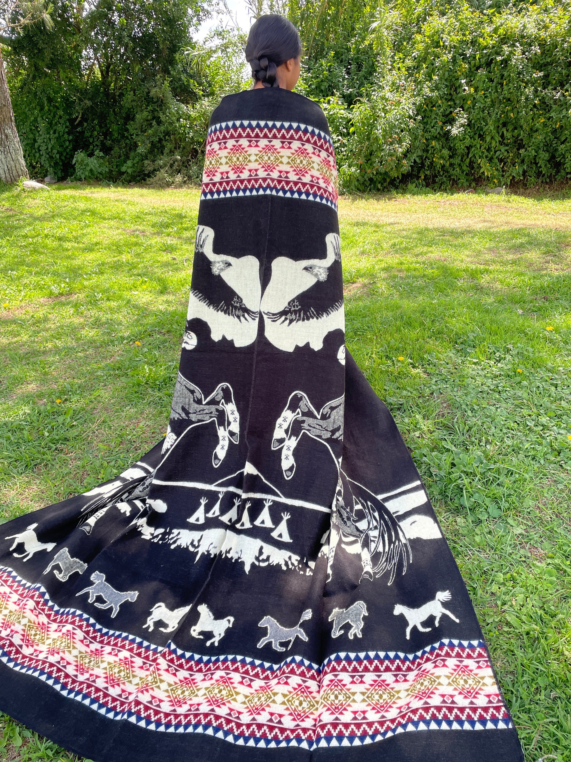 TomHats alpaca blanket in black, featuring eagle and horse motifs as well as traditional indigenous patterns, made of soft wool.
