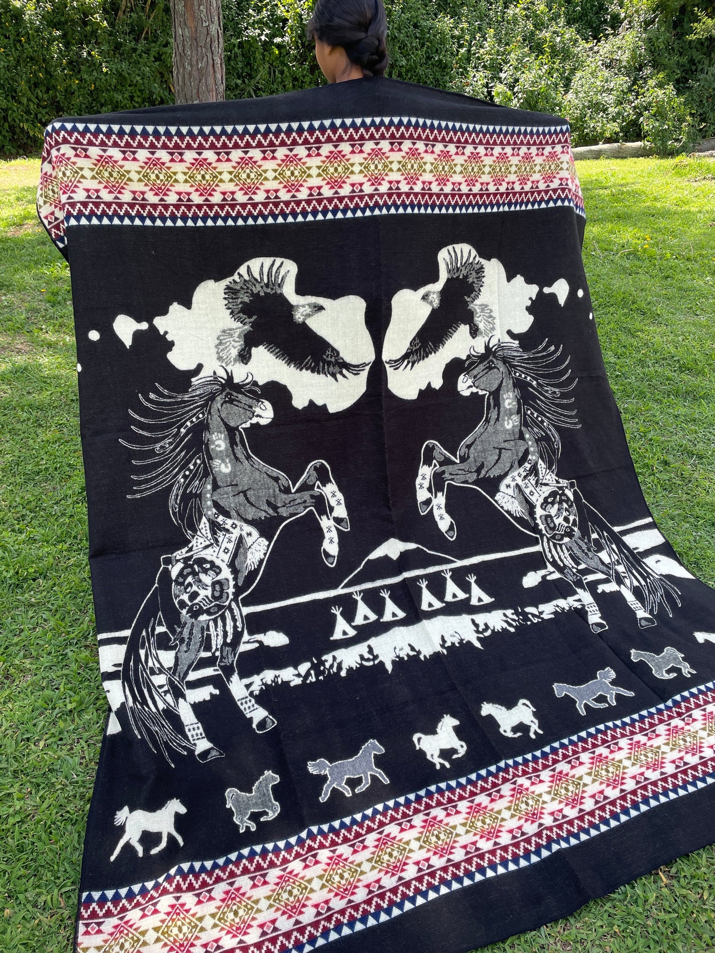TomHats alpaca blanket in black, featuring eagle and horse motifs as well as traditional indigenous patterns, made of soft wool.