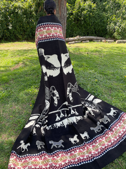 TomHats alpaca blanket in black, featuring eagle and horse motifs as well as traditional indigenous patterns, made of soft wool.