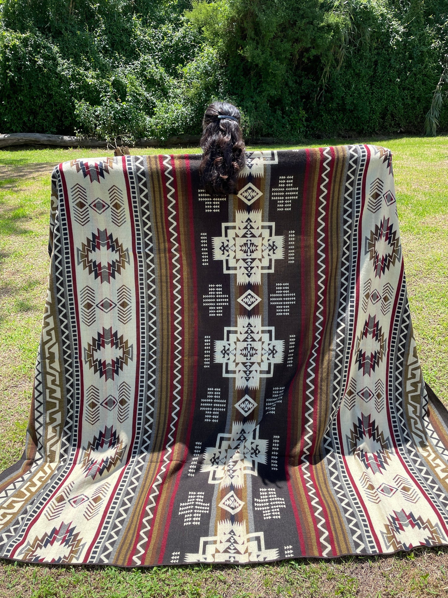 TomHats brown alpaca blanket featuring traditional indigenous geometric patterns, handmade and displayed outdoors.