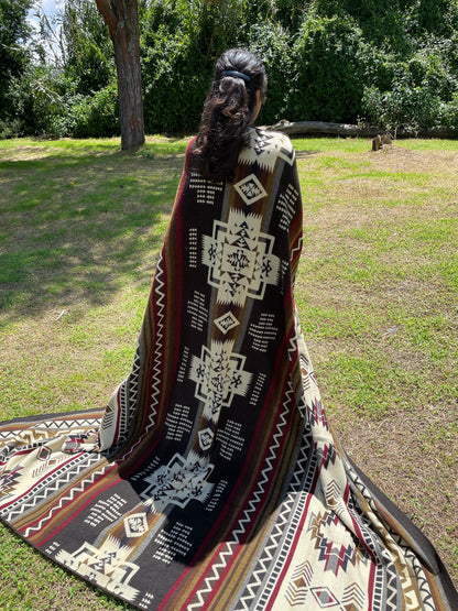 TomHats brown alpaca blanket featuring traditional indigenous geometric patterns, handmade and displayed outdoors.