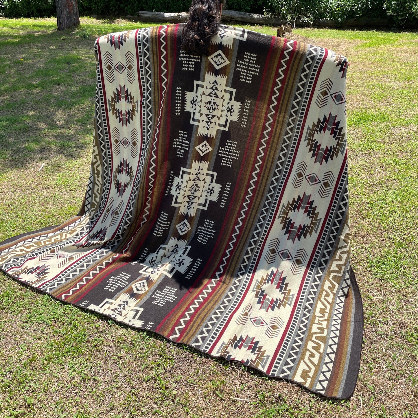 TomHats brown alpaca blanket featuring traditional indigenous geometric patterns, handmade and displayed outdoors.