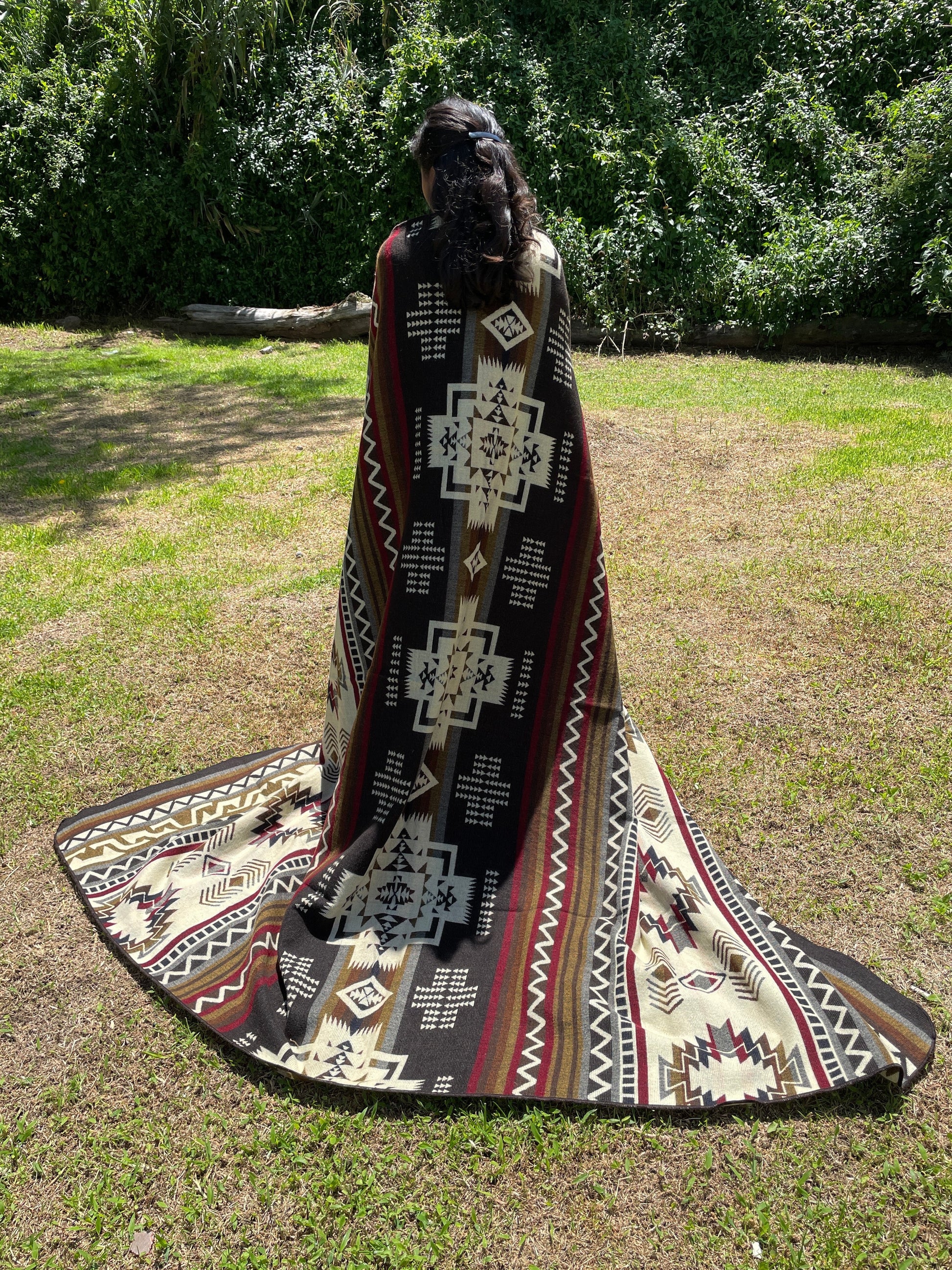 TomHats brown alpaca blanket featuring traditional indigenous geometric patterns, handmade and displayed outdoors.
