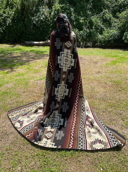 TomHats brown alpaca blanket featuring traditional indigenous geometric patterns, handmade and displayed outdoors.