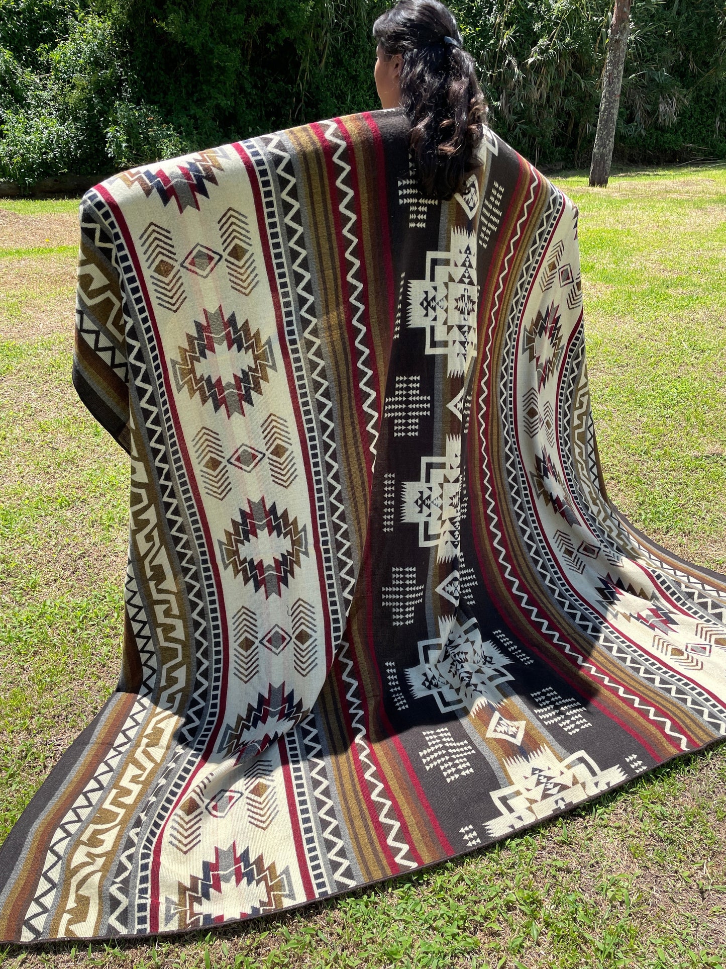 TomHats brown alpaca blanket featuring traditional indigenous geometric patterns, handmade and displayed outdoors.